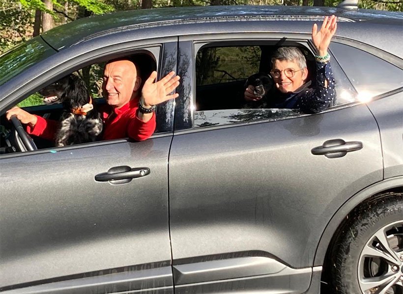 Couple arrivant en voiture avec leur chien au Domaine du Lac de Soursac, accueil convivial et séjour facile en pleine nature