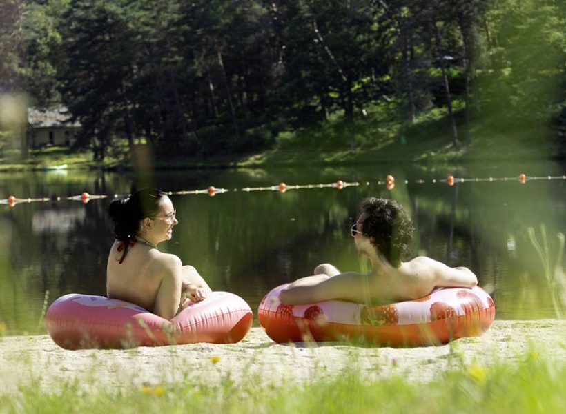 bouee-lac Deux personnes détendues sur des bouées, assises au bord du lac du Domaine du Lac de Soursac, profitant du calme et du soleil